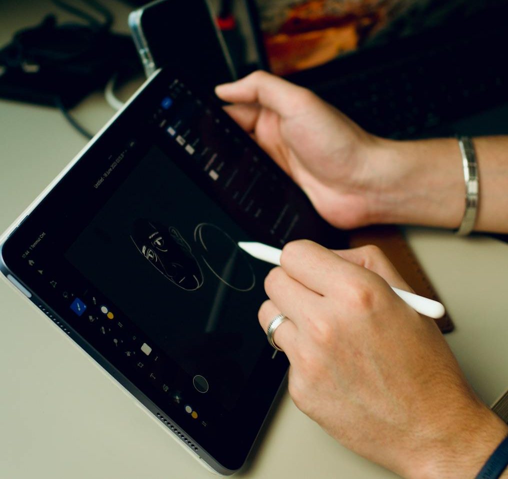 Person drawing digital art on a tablet indoors, showcasing technology and creativity.